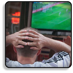 Male Holding Head Looking at TV
