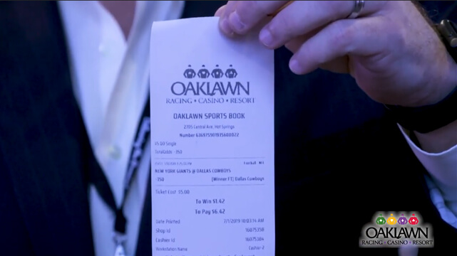 Man Holding a Oaklawn Sports Betting Ticket1