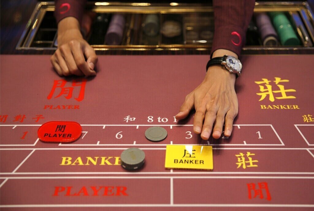 Image of a real life game of Baccarat, showing a bet on the banker.