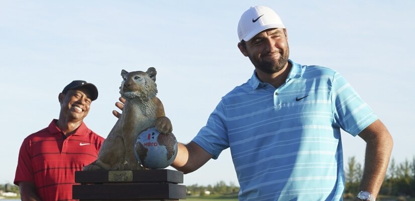 Photo of Hero International winner Scottie Scheffler with Tiger Woods Looking on in the background.