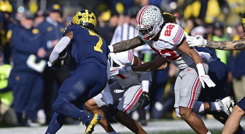 Photo of Ohio State linebacker Steele Chambers tackling Michigan Wolverines running back Donovan Edwards during