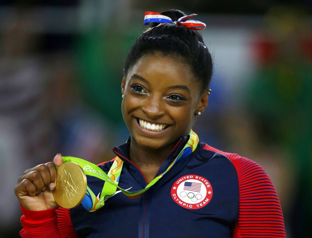Simone Biles with a gold medal at the 2016 Brazil Olympics.