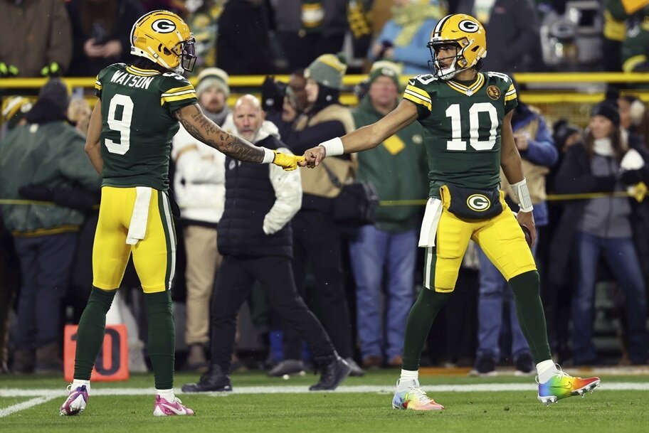 Jordan Love and Christian Watson of the Green Bay Packers get ready for an NFL game.