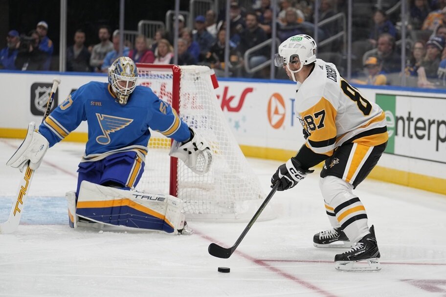 Pittsburgh's Sidney Crosby looks to make a move on St. Louis' Jordan Binnington.