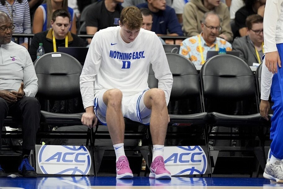 Cooper Flagg looks at his injured ankle during the ACC Tournament.