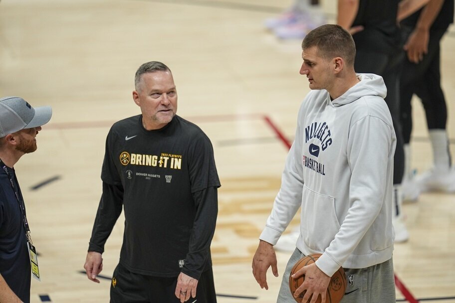 Denver's Michael Malone and Nikola Jokic talk before a game.
