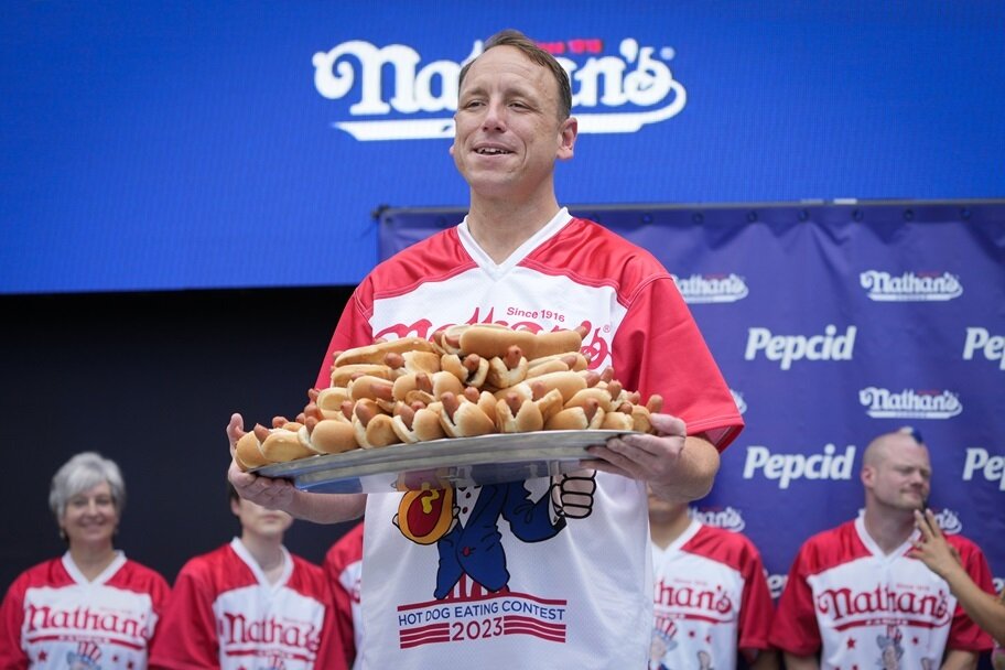 Joey Chestnut posts with a tray of hot dogs.