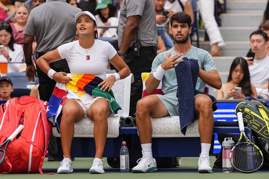 Emma Raducanu and Carlos Alcaraz rest during their US Open mixed doubles match.