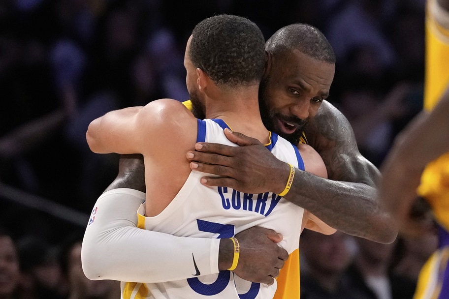 LeBron James and Stephen Curry hug after an NBA game.