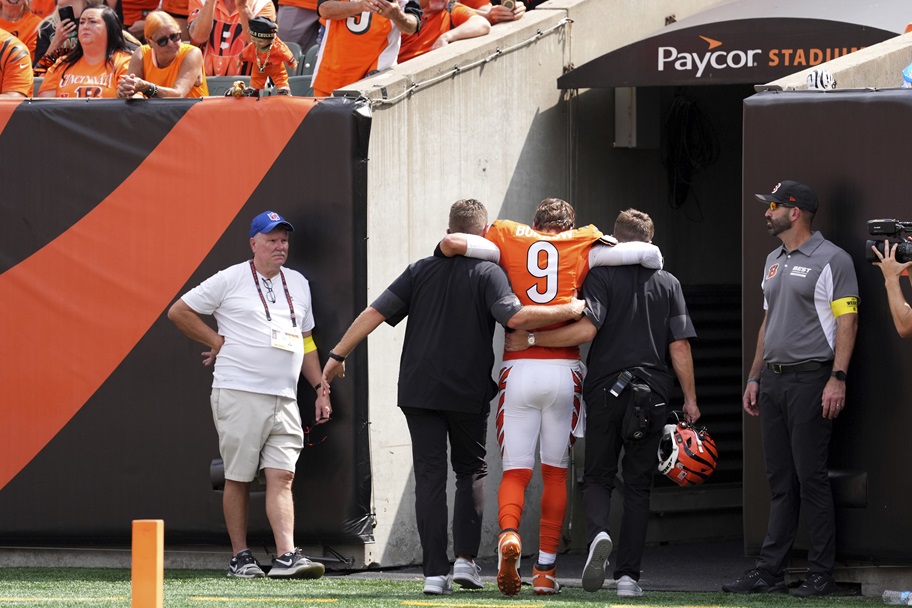 Cincinnati's Joe Burrow is helped off the field after an injury.